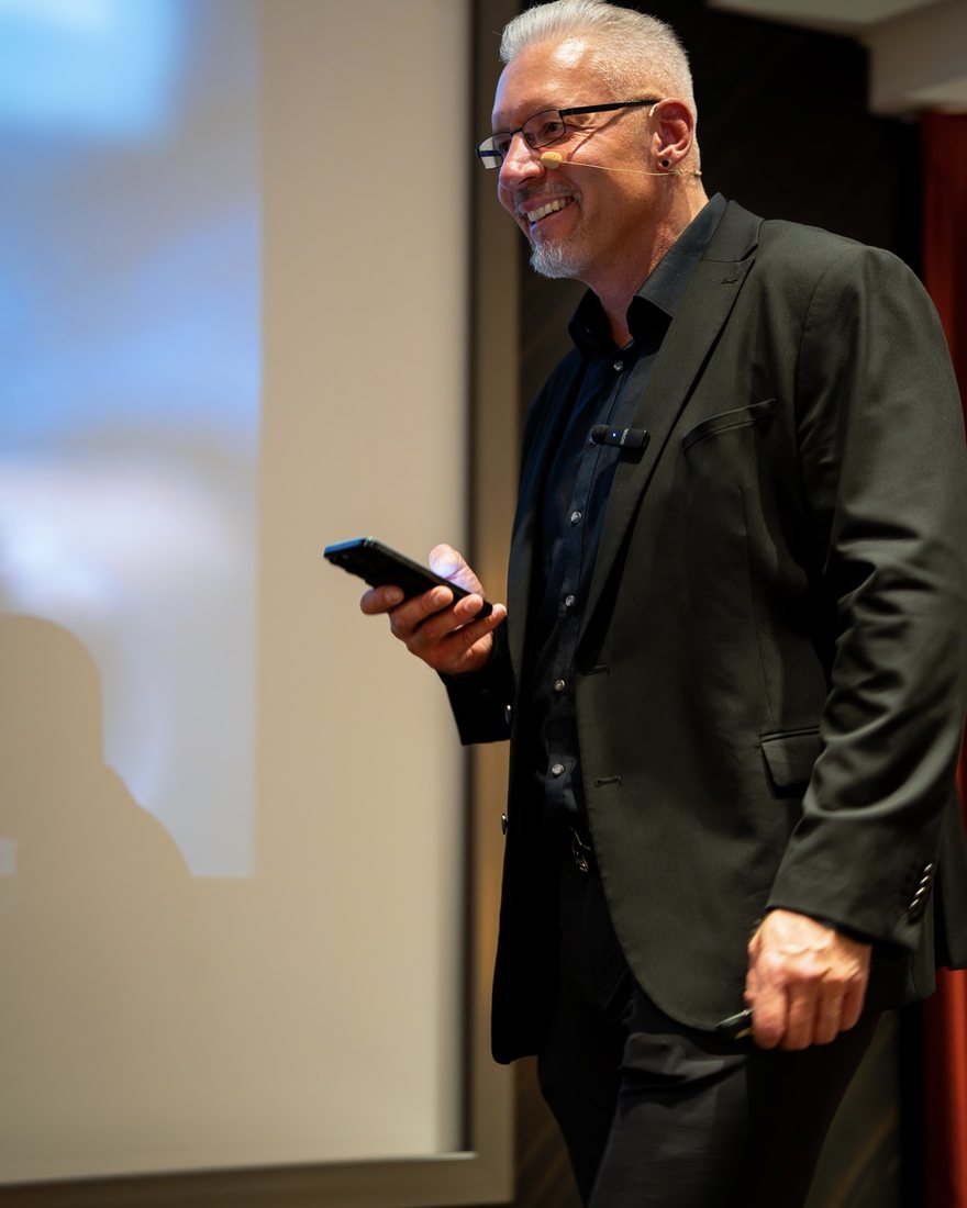 Reiner Küstner lächelnd mit dem Handy in der Hand