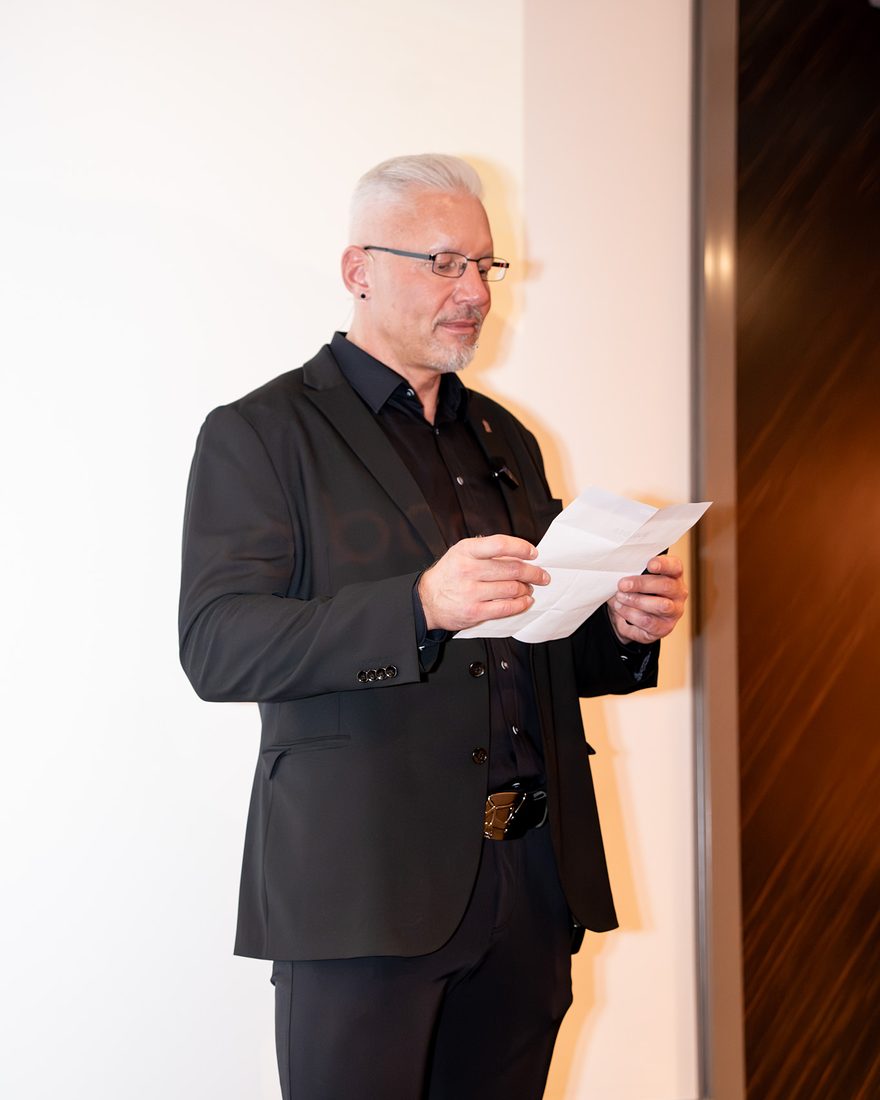 Reiner Küstner liest ruhig in einem Blatt Papier